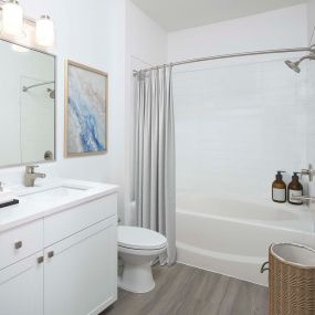 Modern style bathroom with wood-look flooring and quartz countertops at Camden Royal Palms apartments in Brandon, FL