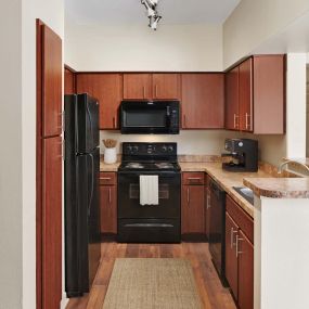 Kitchen with black and stainless appliances at Camden Stonebridge Apartments in Houston, TX