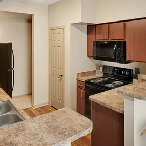 Kitchen with black and stainless appliances at Camden Stonebridge Apartments in Houston, TX