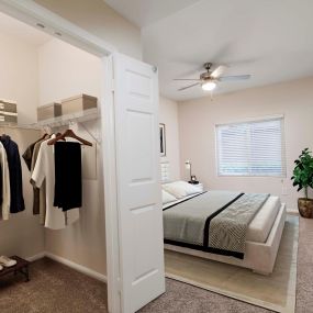 Bedroom with ceiling fan and walk in closet
