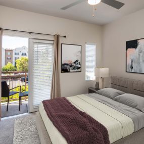 Townhome bedroom with ceiling fan and french doors to balcony
