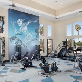 Fitness center cardio equipment with windows and a ceiling fan