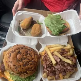 Image of two takeout containers filled with best halal burgers and food in Dearborn at Taystee's