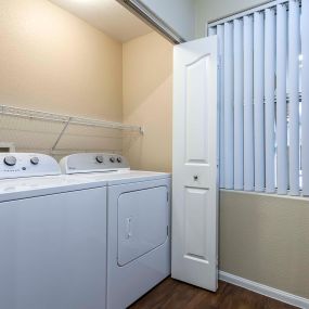 Full size washer and dryer with shelves and a window