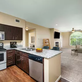 Open-concept kitchen with stainless steel appliances near living room