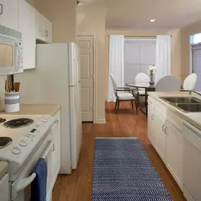 Neighborhood one kitchen with white appliances electric cooktop and wood look flooring