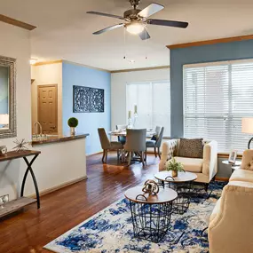 Neighborhood two living and dining room with dark crown molding wood look floors and ceiling fan