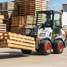 A Bobcat L28 small articulated loader with pallet fork attachment