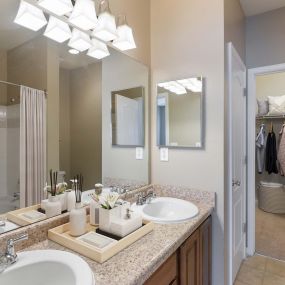 Traditional style bathroom with double sinks and walk in closets