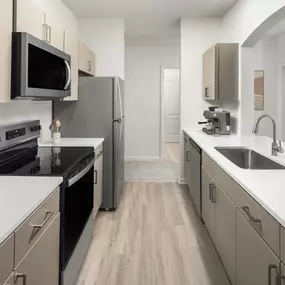 Chef-inspired kitchen with quartz countertop and stainless steel appliances at Camden Westwood apartments in Morrisville, NC