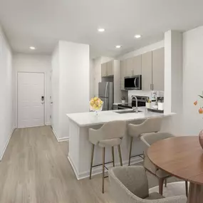 Contemporary-style kitchen with stainless steel appliances and wood-look flooring throughout at Camden Westwood apartments in Morrisville, NC