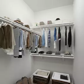 Walk-in closet with wood-style flooring at Camden Westwood apartments in Morrisville, NC
