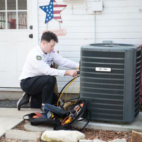 Air conditioner repair technician hard at work in the Dallas, TX area.