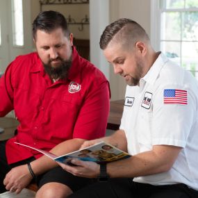 A heating and AC repair technician going over repair plans in the Frisco, TX area.
