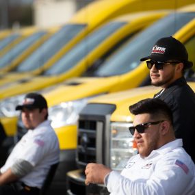 Some of the amazing staff at One Hour with the service vehicle fleet in the Dallas, TX area.