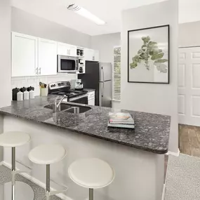 Kitchen with breakfast bar and stainless steel appliances at Camden Denver West Apartments in Golden, CO