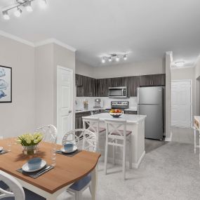 Dining area and kitchen with track lighting and white crown molding