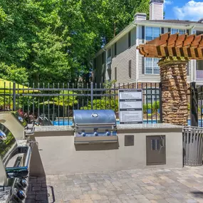 Grilling area with multiple grills and ample seating adjacent to the pool deck