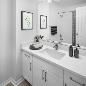 Renovated bathroom with white quartz countertops and white cabinets at Camden Cimarron apartments in Irving, Tx