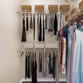 Large walk-in closet with built-in shelves and wood-style flooring at Camden Cimarron