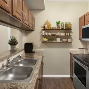 Kitchen with stainless steel appliances and bartop counter at Camden Cimarron