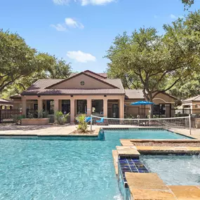 Resort-style pool with volleyball net and fountain at Camden Cimarron apartments in Irving, TX