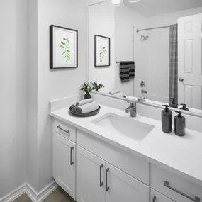 Renovated bathroom with white quartz countertops and white cabinets at Camden Cimarron apartments in Irving, Tx