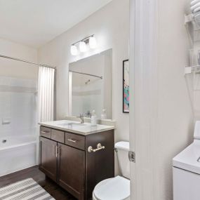 Bathroom with bathtub at Camden Ashburn Farm in Ashburn, Virginia.  Attached laundry room with full size washer, dryer, and storage racks.
