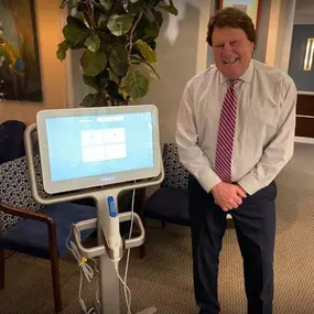 Dr. Jack Bodie standing besides dental equipment.