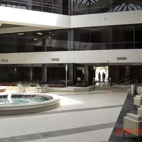 courtyard inside building with water fountain in the center and sitting area to the right