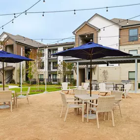 Courtyard with outdoor grills, string lights, and dining area