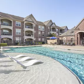 Resort-style pool with water features and sun loungers at Camden Cypress Creek Apartments in Cypress, Tx