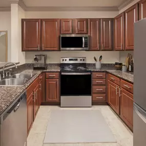 Traditional style kitchen with stainless steel appliances and granite countertops at Camden Cypress Creek Apartments in Cypress, TX