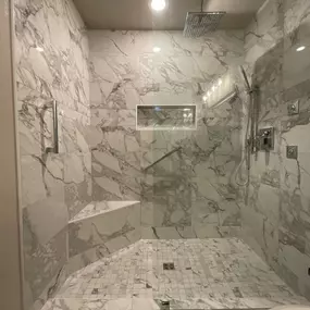 Custom Aging in Place walk in shower with Marble Attache tile. Grab bars, custom shower bench, body sprays, handheld wand, and rain shower head. Luxury shower!