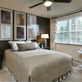 Bedroom with double window carpet and lighted ceiling fan