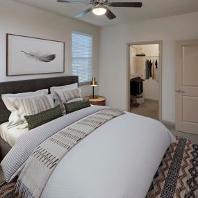 Bedroom with great natural light, ceiling fan, and large walk-in closet
