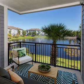 Balcony with storage and view of lake and water fountain