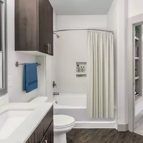 Ensuite bathroom with bathtub with tile surround and curved shower rod at Camden Southline