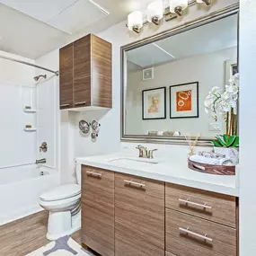 Bathroom with quartz countertops bathtub with tile surround and curved shower rod