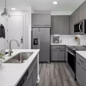 Camden Tempe West Apartments Tempe Arizona contemporary kitchen with gray cabinets and white quartz countertops with stainless steel appliances and side-by-side refrigerator