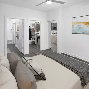 Camden Tempe West Apartments Tempe Arizona contemporary main bedroom with gray wood-like flooring, a lighted ceiling fan, ensuite bathroom and closet with built-in wooden shelves and rods