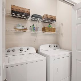 Laundry space with washer and dryer included plus shelves above at Camden Shadow Brook