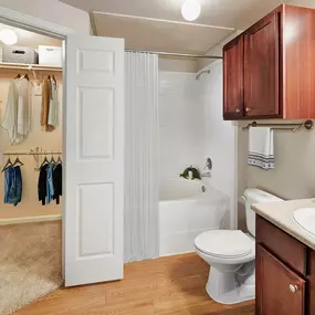 Bathroom with light countertops, bathtub and walk-in closet at Camden Shadow Brook