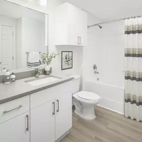 Bathroom with white cabinets, taupe countertops, and bathtub at Camden Shadow Brook apartments in Austin, TX