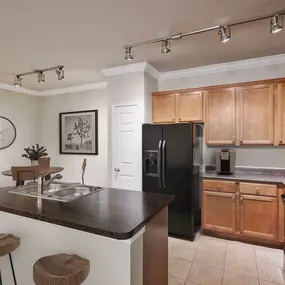 First floor kitchen with island and tile flooring at Camden Shadow Brook in Austin, TX