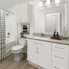 Renovated bathroom with white cabinets and beige grey quartz countertops at at Camden Shadow Brook apartments in Austin, TX