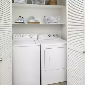 Laundry closet with full size washer and dryer and built-in shelves at Camden Shadow Brook apartments in Austin, TX