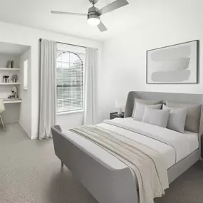 Bedroom with built-in desk nook, carpet, arched window, and modern ceiling fan at Camden Shadow Brook apartments in Austin, TX