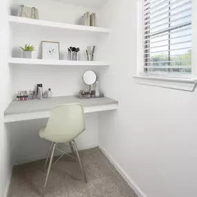 Built-in desk bedroom nook with shelves and a small window at Camden Shadow Brook apartments in Austin, TX