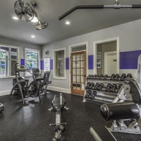 24 hour fitness center with cardio and strength training equipment including free weights